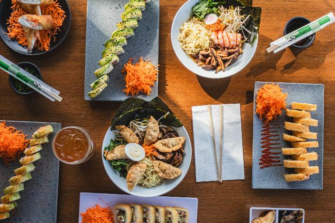 A wooden table topped with plates of food