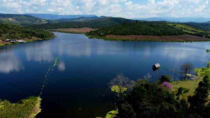 a body of water with trees and hills around it